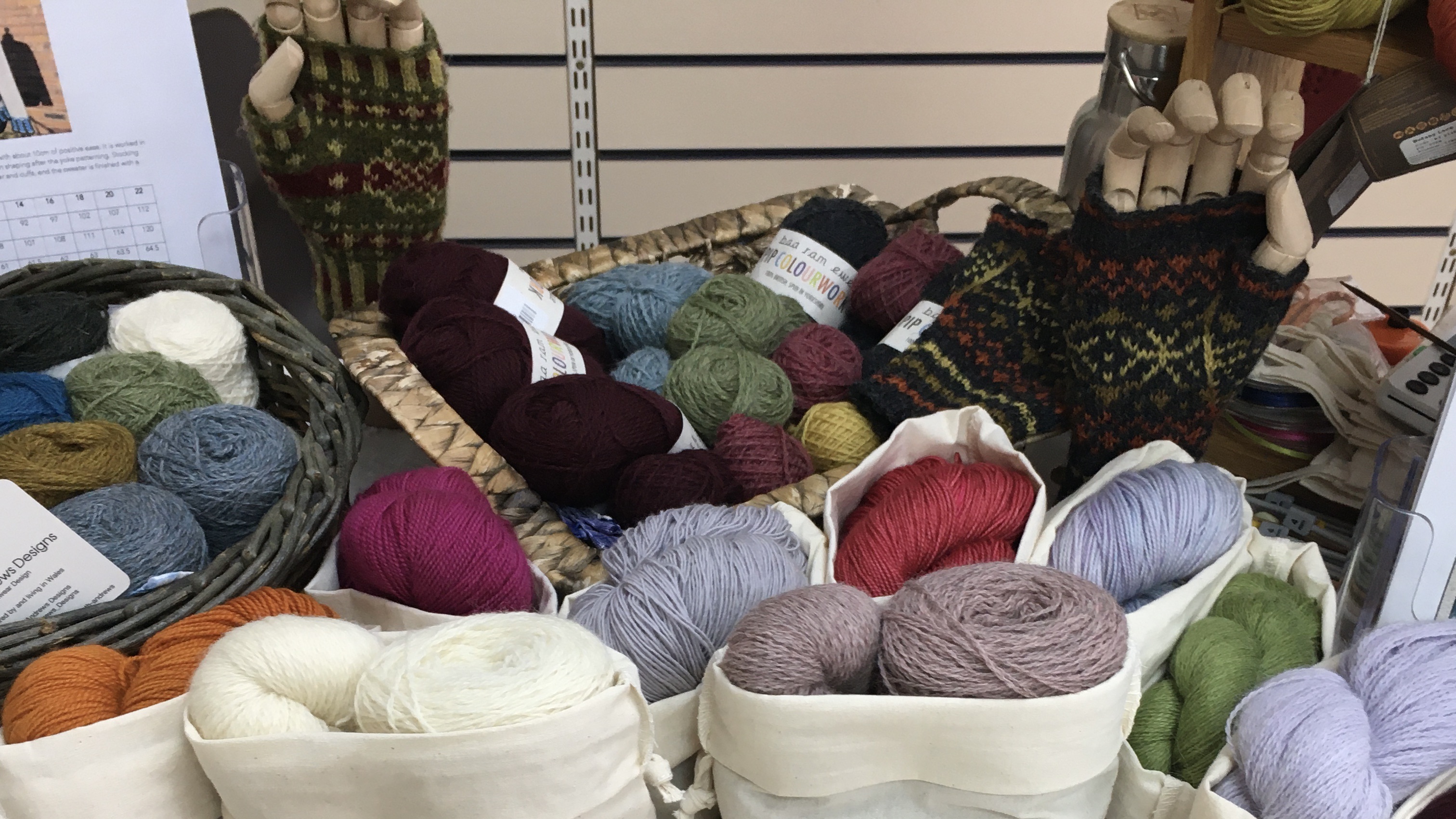 A close-up shot of part of my table at the pop-up shop in Feb 2020 - various yarn kits, patterns and knitted samples arrayed on the table.